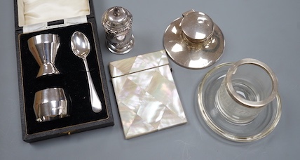 A 1930's cased silver christening trio, a silver mounted inkwell, a silver pepperette, a silver mounted glass match strike/ashtray and a mother of pearl card case.